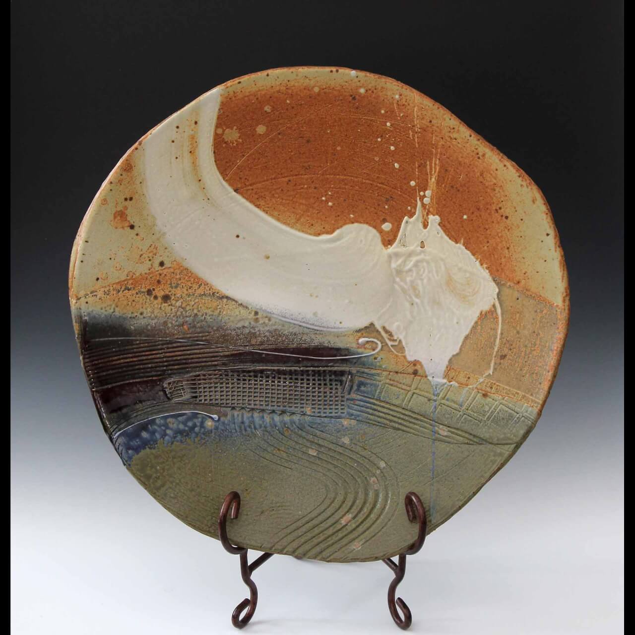 image of plate with muted earth tone glazes