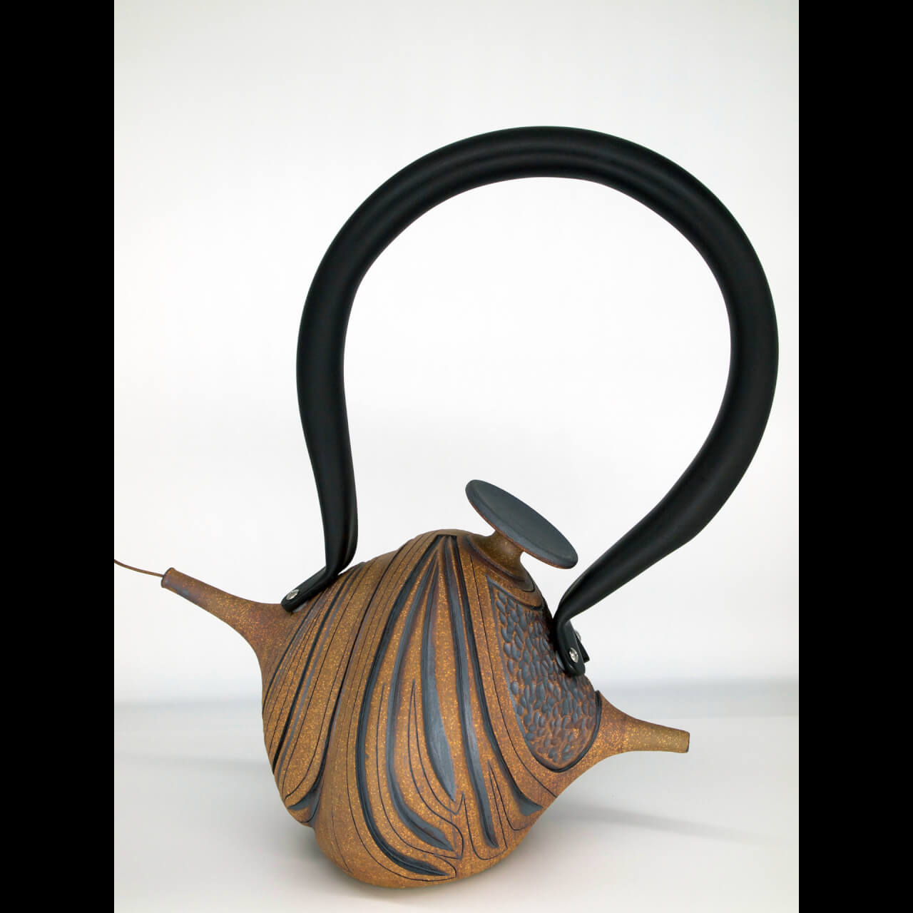 asymmetrical teapot with large black handle