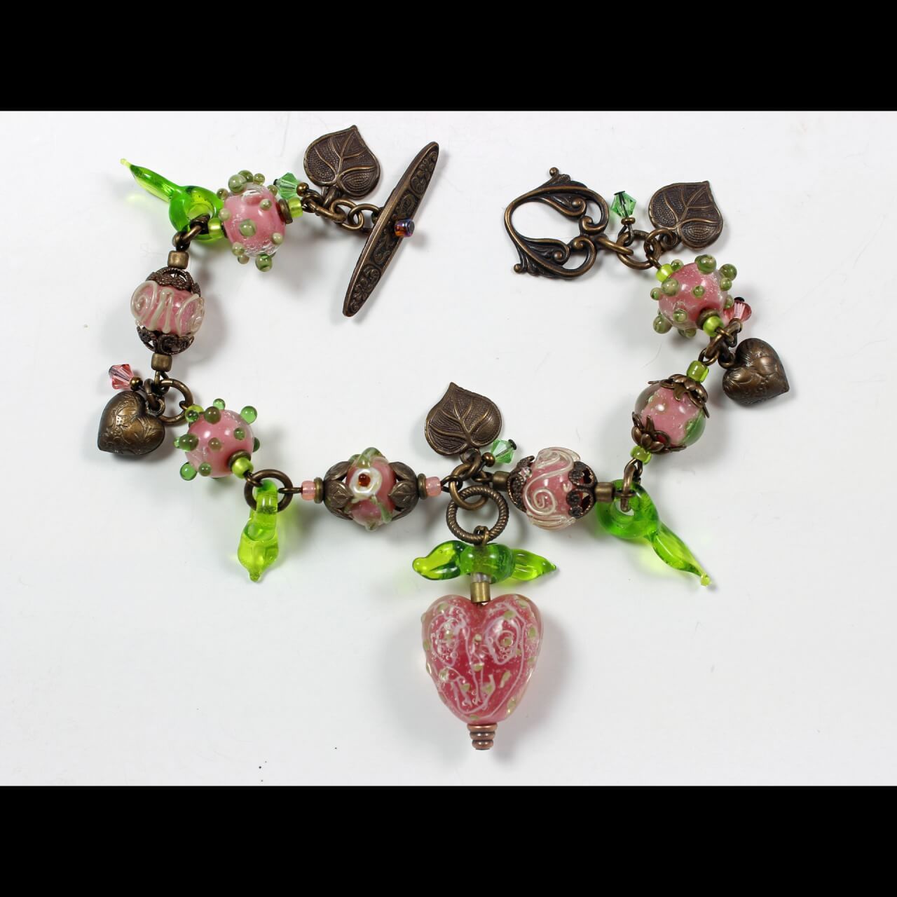 bracelet made with pink and green beads on brass chain